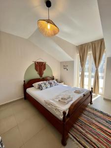 布德瓦Villa Merci Budva的一间卧室配有一张大床和一个吊灯。
