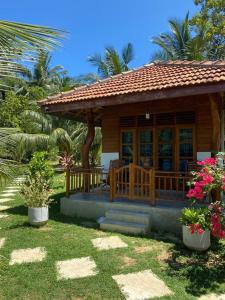 坦加拉Hanguk Lanka Lagoon Villa的一座小房子,有门廊和一些植物