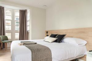 蓬特德乌梅Albatros的卧室配有一张带白色床单和枕头的大床。