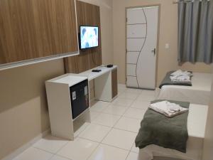 圣阿马鲁Pousada Rota das Dunas de Amaro的客房设有两张床和一台平面电视。