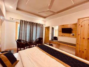 马拉里Hotel Radhika Manali的配有一张床和一张书桌的酒店客房