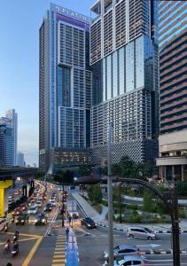 吉隆坡The Platinum 2 KLCC Premium Suite by Reluxe Kuala Lumpur的一条繁忙的城市街道,高楼前有交通