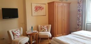 奥贝里德Gasthaus Sternen Post的一间卧室配有一张床、两把椅子和一张桌子
