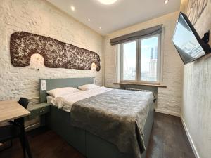 基辅Kyiv Panorama Apartments near Gulliver的一间卧室配有一张床、一张书桌和一个窗户。