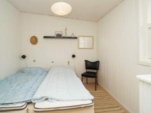 霍尔拜克Holiday home Holbæk III的一间卧室配有一张床和一张黑椅