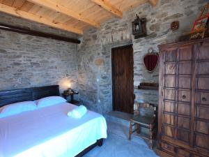 PotamósHill's Barbacane的一间卧室设有一张床和石墙
