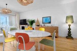 奥尔比亚Olbia Luxury Apartment的一间配备有白色桌椅的用餐室
