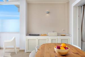 奥尔比亚Olbia Luxury Apartment的厨房配有带一碗水果的木桌