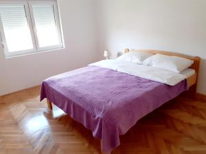 Gornja ToplicaApartman Predah Banja Vrujci的一间卧室配有一张带紫色毯子的床