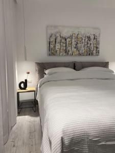 雅西Downtown Chic 2的卧室配有白色的床和墙上的绘画作品