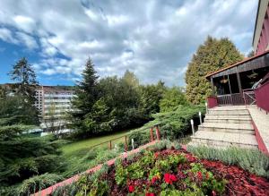 巴德霍夫斯基库佩莱佐尼卡旅馆的一座花园,在一座建筑前有鲜花和楼梯