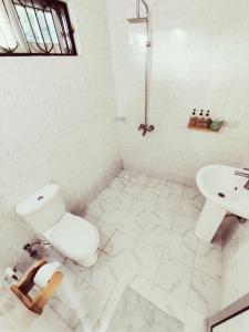 帕杰Hakuna Matata Boutique的白色的浴室设有卫生间和水槽。