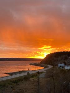 Saint-FulgenceSuite 2, Flèche du fjord, vue Saguenay, Mont Valin的一条路在水体上的日落