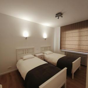 尼乌波特Stijlvol appartement met zeezicht Nieuwpoort的小型客房 - 带2张床和窗户