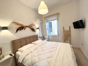科孚镇Nenas Volto Apartment的卧室配有白色的床,墙上有鸟