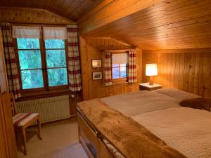 林根贝格Chalet Rosemarie的木制客房内的一间卧室,配有一张床
