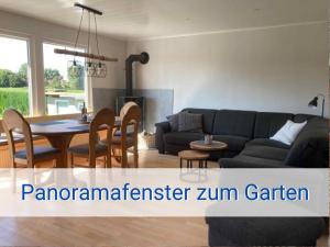 NeukirchenSTRANDLIEBE 100 qm Gartenwohnung (eingezäunt), 15 Gehminuten zum Strand的客厅配有沙发和桌子