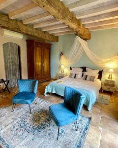 Terraube阿杜尔住宿加早餐旅馆的一间卧室配有一张床和两张蓝色椅子