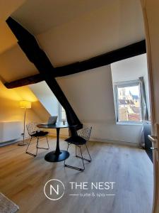 桑利斯The Nest. duplex jacuzzi hyper centre de Senlis的客房设有桌椅和窗户。