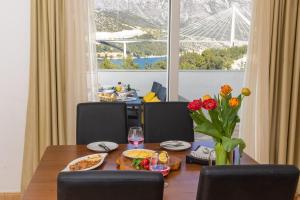 杜布罗夫尼克尔娜别墅酒店的用餐室配有带食物和鲜花的桌子