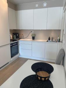 特罗姆瑟Leilighet sentralt i Tromsø的厨房配有白色橱柜和桌子