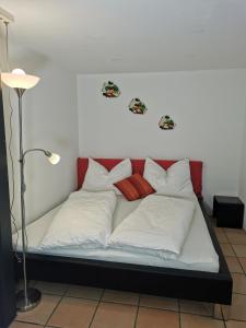 阿尔贝施文德Studio Mario的一张带白色和红色枕头的床