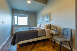 雷克雅未克Iceland SJF Apartments - 401的一间卧室配有一张床和一把椅子