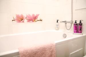 利耶帕亚Magnolia apartment的浴室水槽上放着两朵粉红色的花