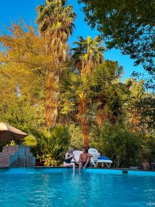 Calle LargaBarros Wellness & Spa Resort Boutique的两人坐在度假村的游泳池里