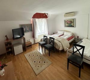 蒂米什瓦拉Georgiana Apartments 2的一间卧室配有一张床、两把椅子和电视