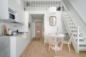 Maple Loft Apartment的白色的厨房和带桌椅的用餐室