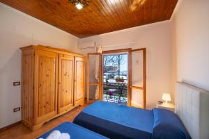 波西塔诺Casa la noce Positano的一间卧室设有蓝色的床和窗户。