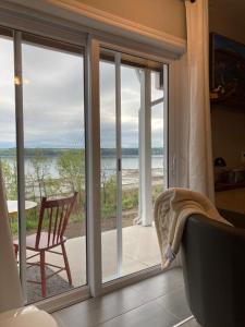 Saint-FulgenceSuite 2, Flèche du fjord, vue Saguenay, Mont Valin的客房设有滑动玻璃门,享有海滩美景