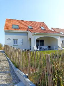 欧丹冈Le Chant des Vagues的白色的房子,有橙色的屋顶和栅栏
