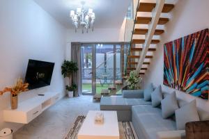 Al QurayyahMasdar Mirage Oasis 2BR Duplex with Pool Access的带沙发和电视的客厅