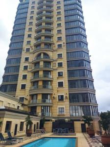 约翰内斯堡Michelangelo Towers 718的一座大型建筑,前面设有一个游泳池