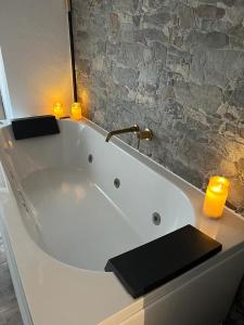 ZarraCasa rural El encanto的浴室内带两个蜡烛的大型白色浴缸