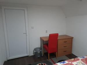 JurumleriSvetlana's Apartments的一间卧室配有书桌和红色椅子