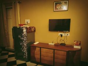 加尔各答OH Kolkata - Sutanuti Homestay的客厅配有电视、桌子和电视机