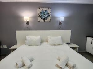 圣卢西亚Hippo Lodge Apartments的卧室配有一张带两个枕头的大白色床