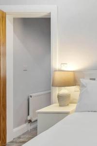 贝尔法斯特Ardoyne Lodge 'Sleeping 4 Guests'的一间卧室,配有一张床和床头灯