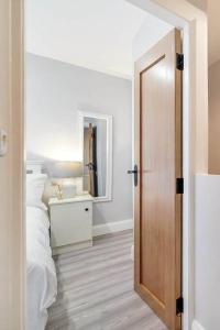 贝尔法斯特Ardoyne Lodge 'Sleeping 4 Guests'的一间卧室配有一张床和一扇木门
