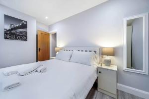 贝尔法斯特Ardoyne Lodge 'Sleeping 4 Guests'的白色的卧室配有白色的床和镜子