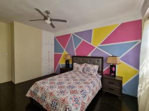 ChoiseulTropical Suites的色彩缤纷的卧室设有床和色彩缤纷的墙壁