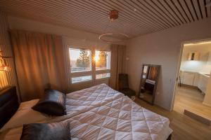 索特Tunturihuoneisto LAAKEUS的一间卧室设有一张大床和一个窗户。
