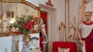 贝雅Império Romano Guest House的一间有红花花的花瓶和花纹的房间