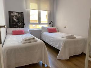 布尔戈斯Contemplando la Catedral by Exclusive Burgos Apartments的配有白色和红色枕头的客房内的两张床