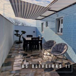 埃斯平霍Casa de Férias_As Oliveiras II的蓝色墙壁上配有桌椅的庭院