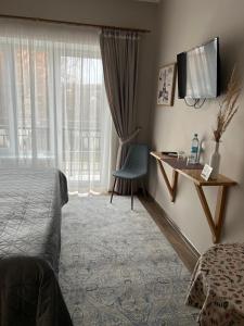 赫梅利尼茨基Tamerlan的配有一张床、一张书桌和一扇窗户的酒店客房