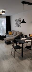 缅济热奇Apartament na Malczewskiego的客厅配有沙发和桌椅